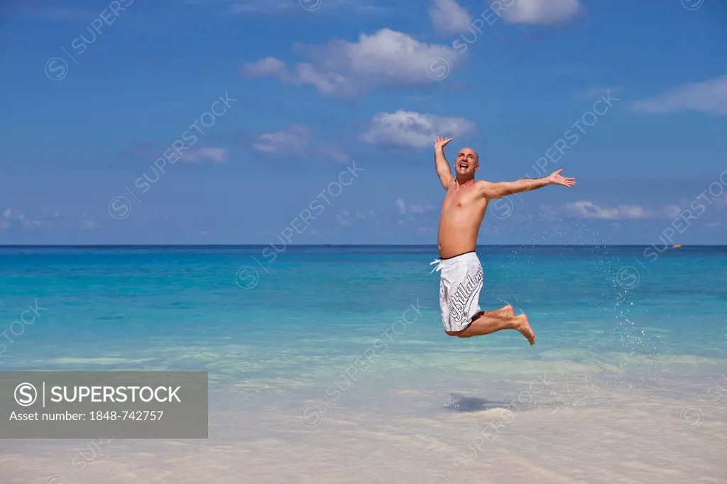 Man, 45, jumping for joy at the beach of Anse Intendance, Mahe, Seychelles, Africa, Indian Ocean