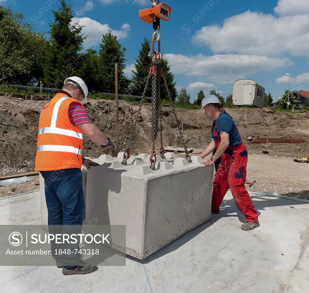Structural engineers placing the first blocks during a building site load test, at a construction site in Fridolfing, Bavaria, Germany, Europe