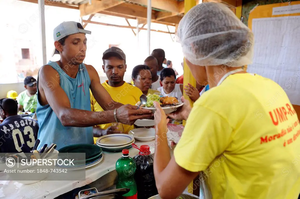 Workers on a building site of the Esperanca housing co-operative receiving lunch, each family helping out on the project and committing to small month...