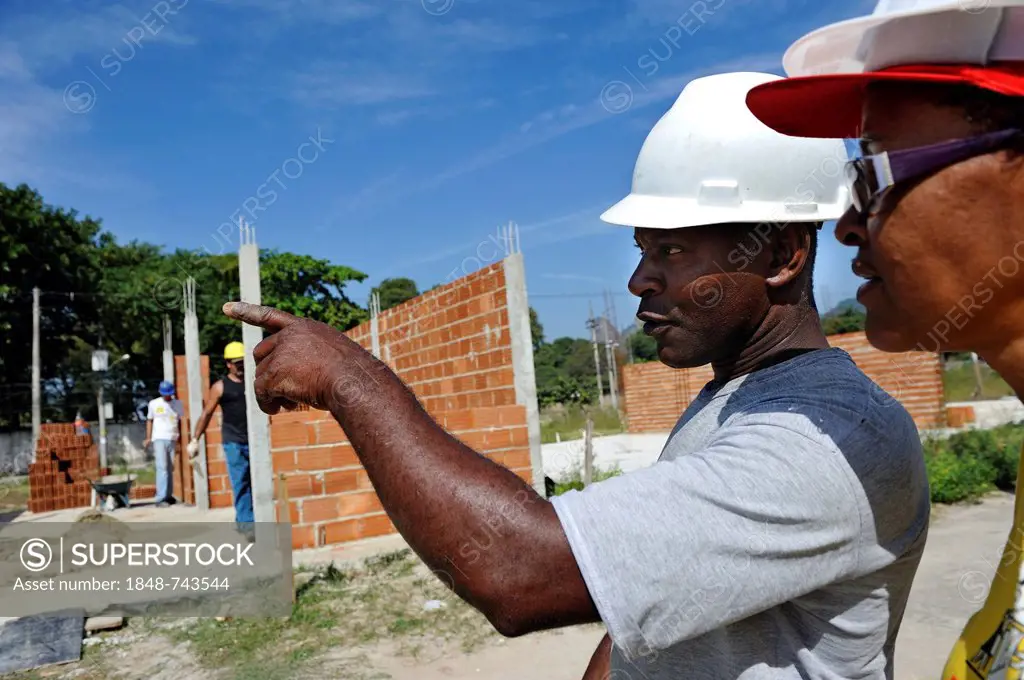 Construction supervisor and the president of the Esperanca housing co-operative inspecting the building site, each family helping out on the project a...