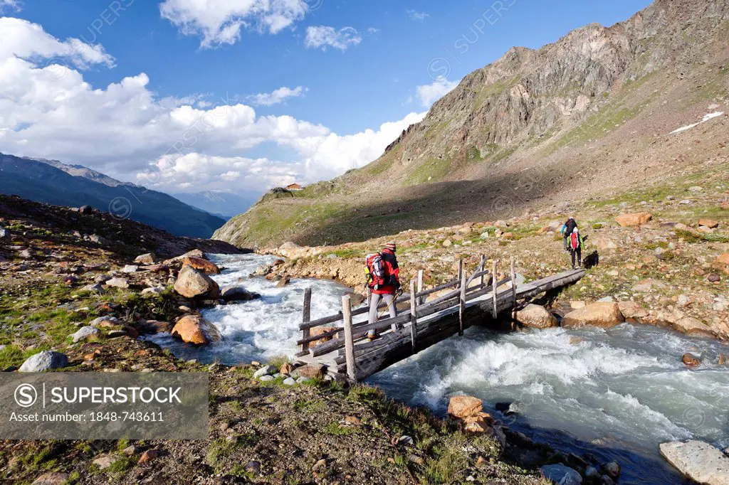 Hikers during the descent from Zufallferner Glacier to Marteller Huette hut, at the rear, in the Martell Valley, Alto Adige, Italy, Europe