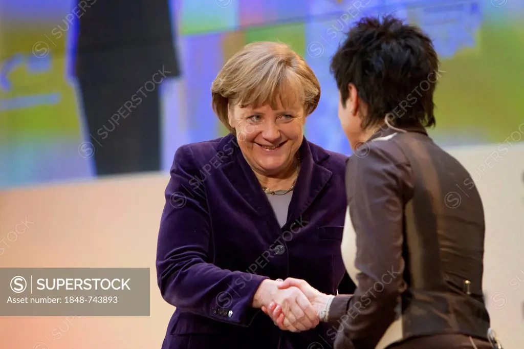 Angela Merkel, the German Federal Chancellor, shaking hands with TV presenter Dunja Hayali during the Goldene Sterne des Sports 2011 award ceremony, B...
