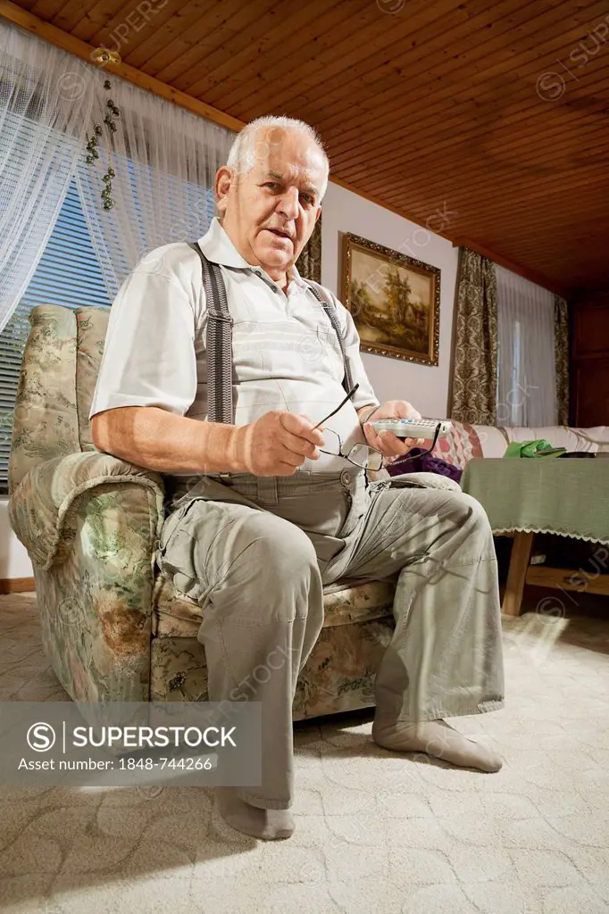 Elderly man holding a remote control