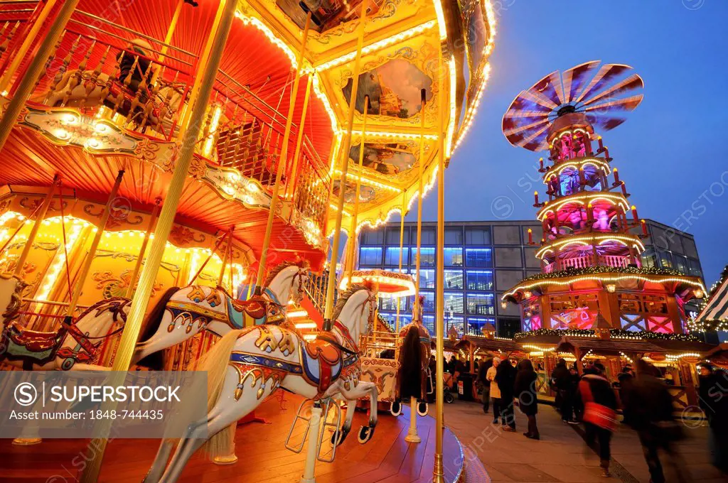 Christmas market on Alexanderplatz square with a children's merry-go-round and a Christmas pyramid, Berlin, Germany, Europe