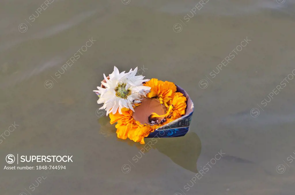 Deepack, little boat with flowers, rice and a small candle, carrying god wishes down the river at Sangam, the confluence of the holy rivers Ganges, Ya...