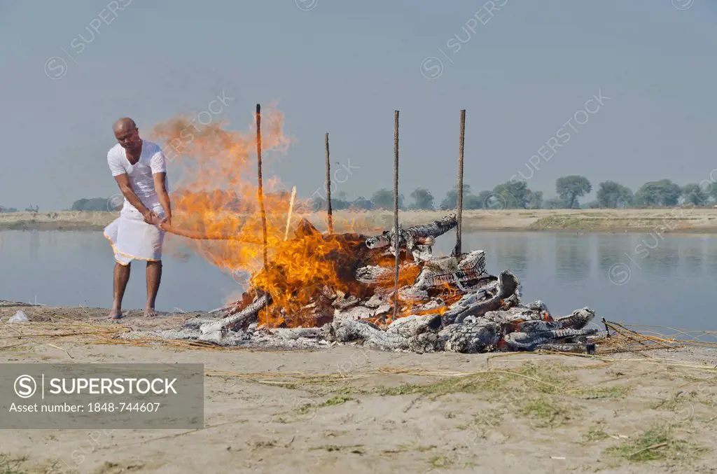 The eldest son maintaining the fire as part of a cremation ceremony, Vrindavan, India, Asia