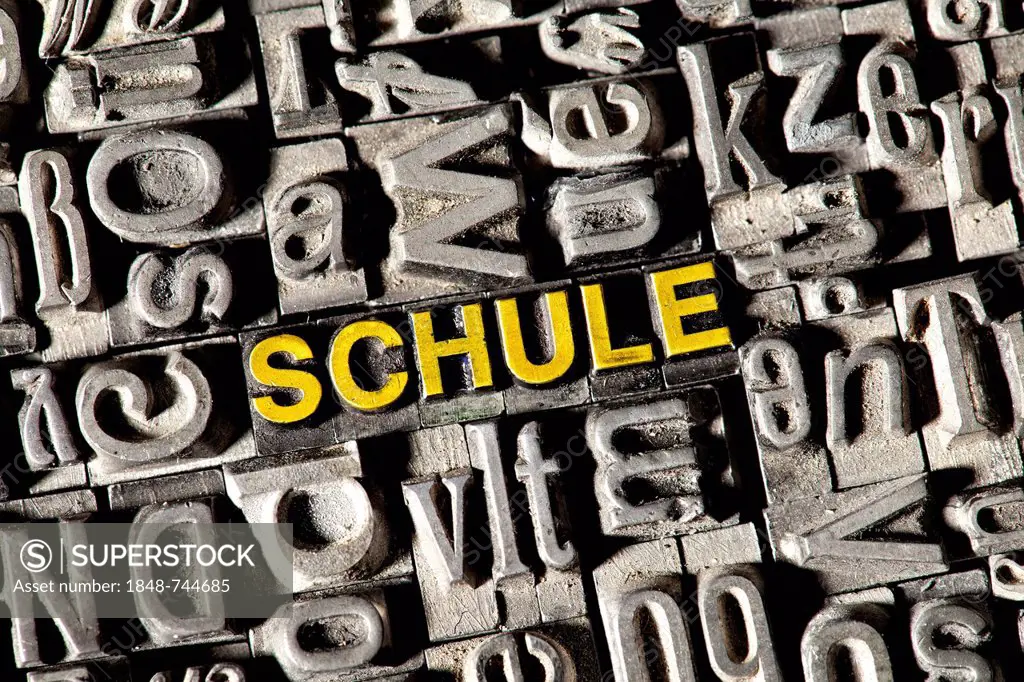 Old lead letters forming the word SCHULE, German for SCHOOL