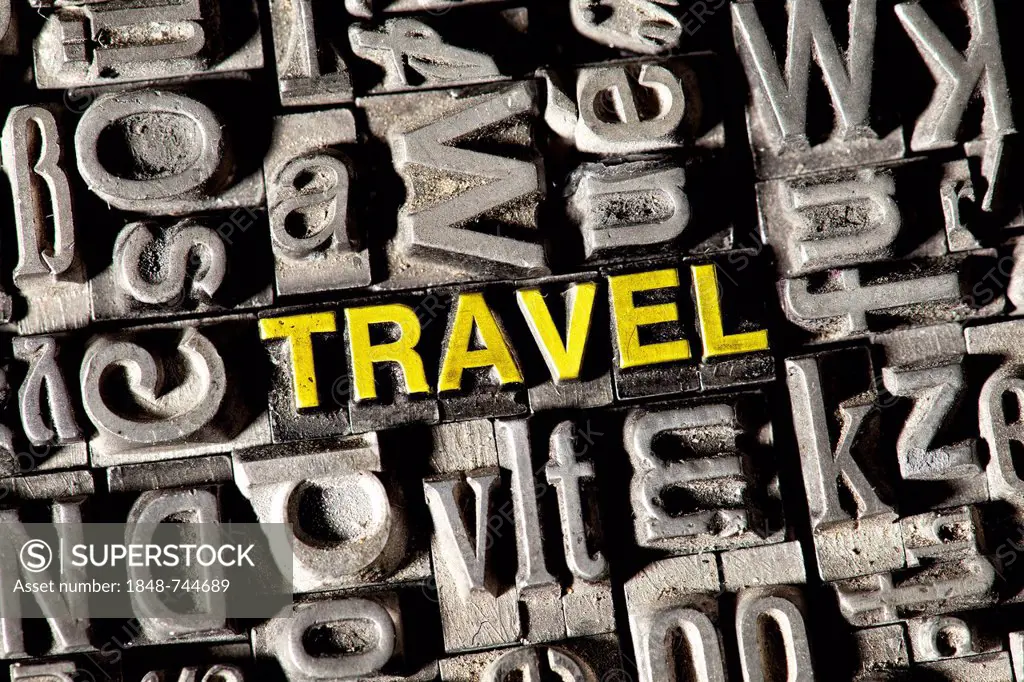 Old lead letters forming the word TRAVEL