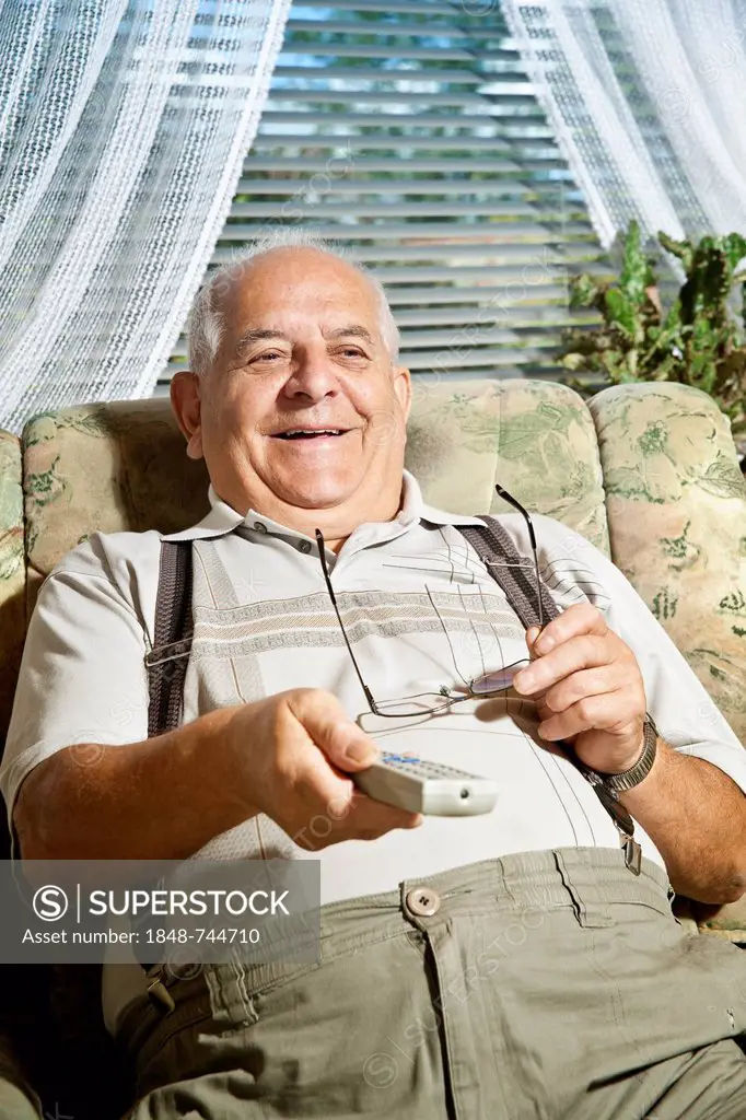 Elderly man operating a remote control