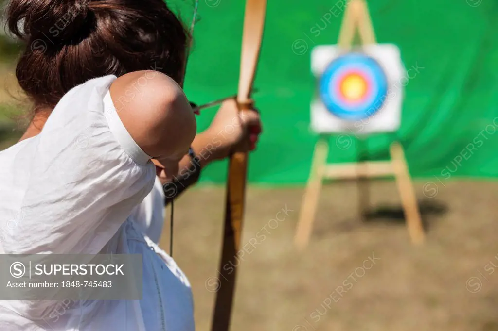 Archer aiming bow and arrow at target, Hesse, Germany, Europe