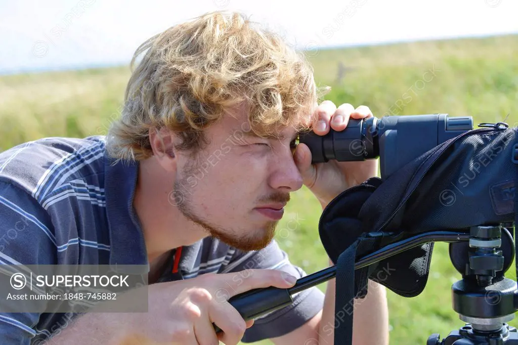 Young man watching something with a spotting scope