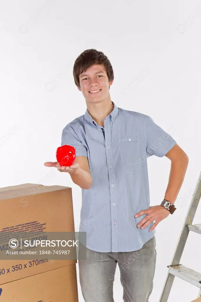 Young man with piggy bank on moving day