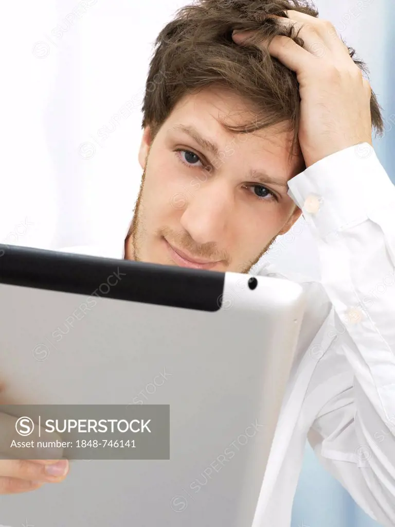Portrait of a businessman, iPad, thoughtful, focused, reflective, hand on head