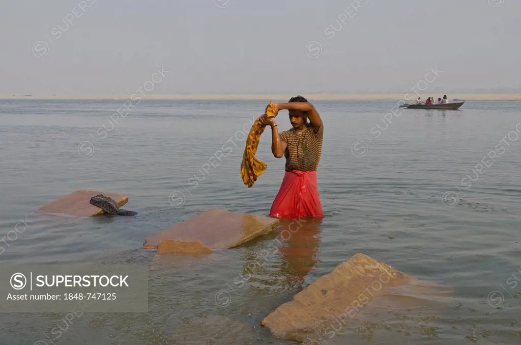 Dhobi wala, a member of the laundry cast, doing his daily work at the ghats of Varanasi along the holy river Ganges, India, Asia
