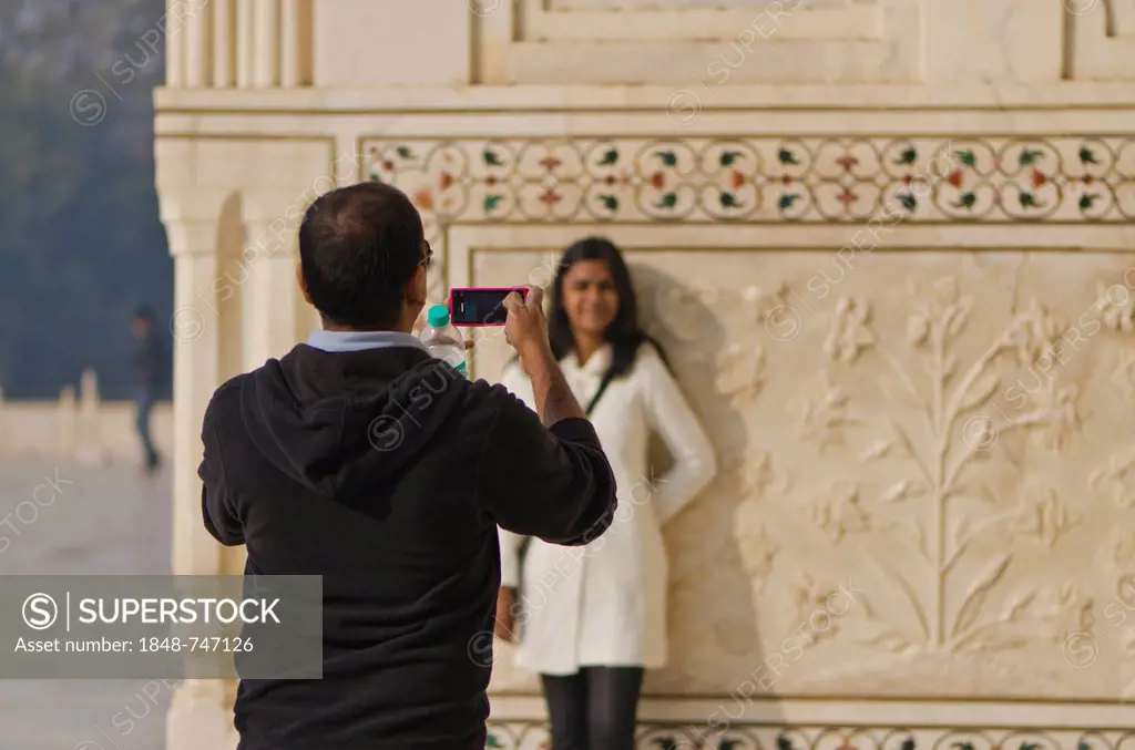 Indian tourist taking a photograph of his wife at Taj Mahal, Agra, India, Asia