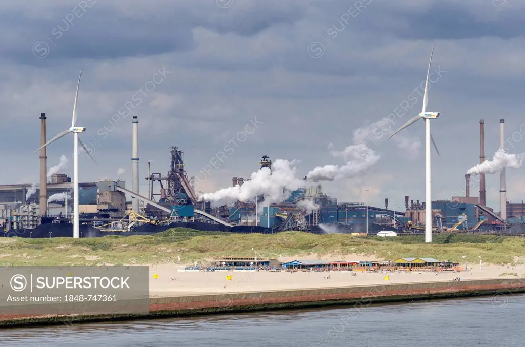 The sandy beach near Wijk aan Zee with beach pavilions, wind turbines and the Tata steel plant at the back, North Holland, the Netherlands, Europe
