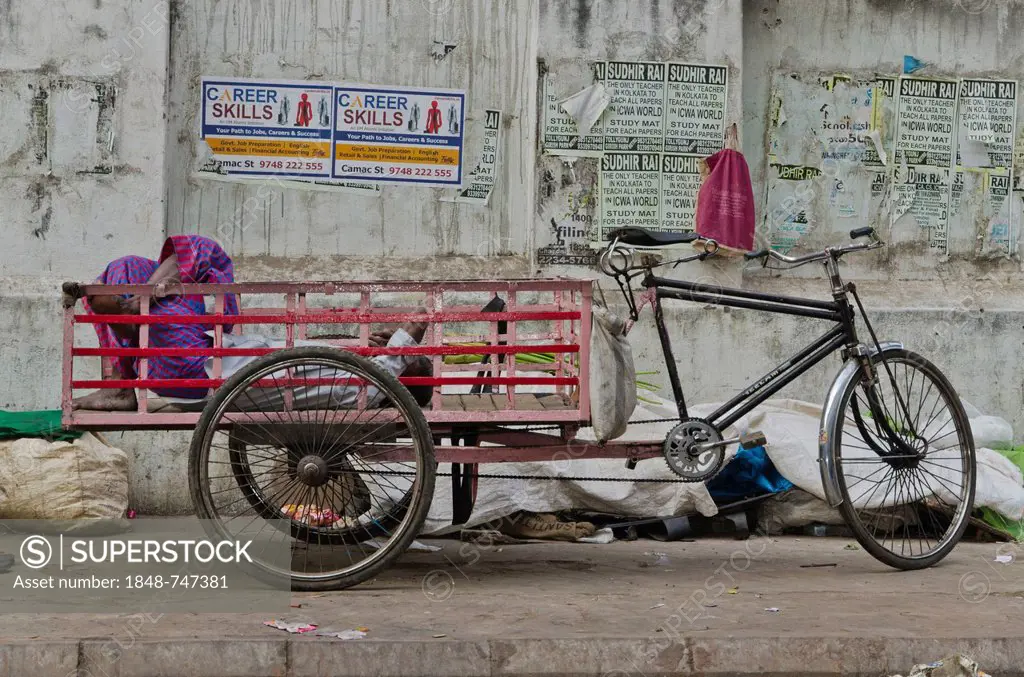 Rikshaw kuli sleeping in the back of his rickshaw, Kolkata, India, Asia