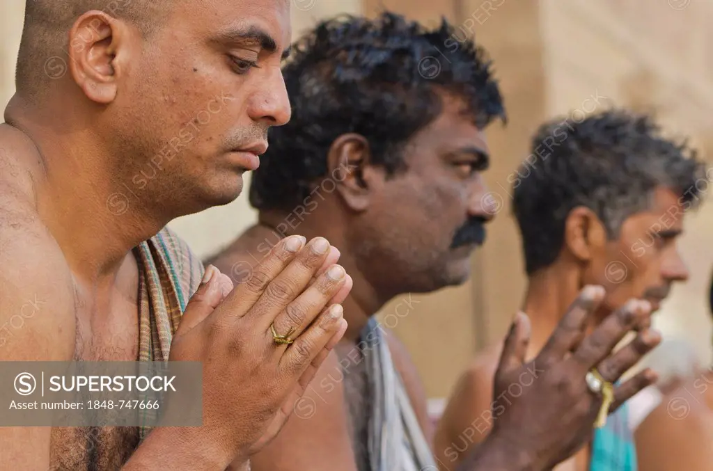 Praying men performing a ritual for the soul of a deceased person, at the ghats of Varanasi, India, Asia