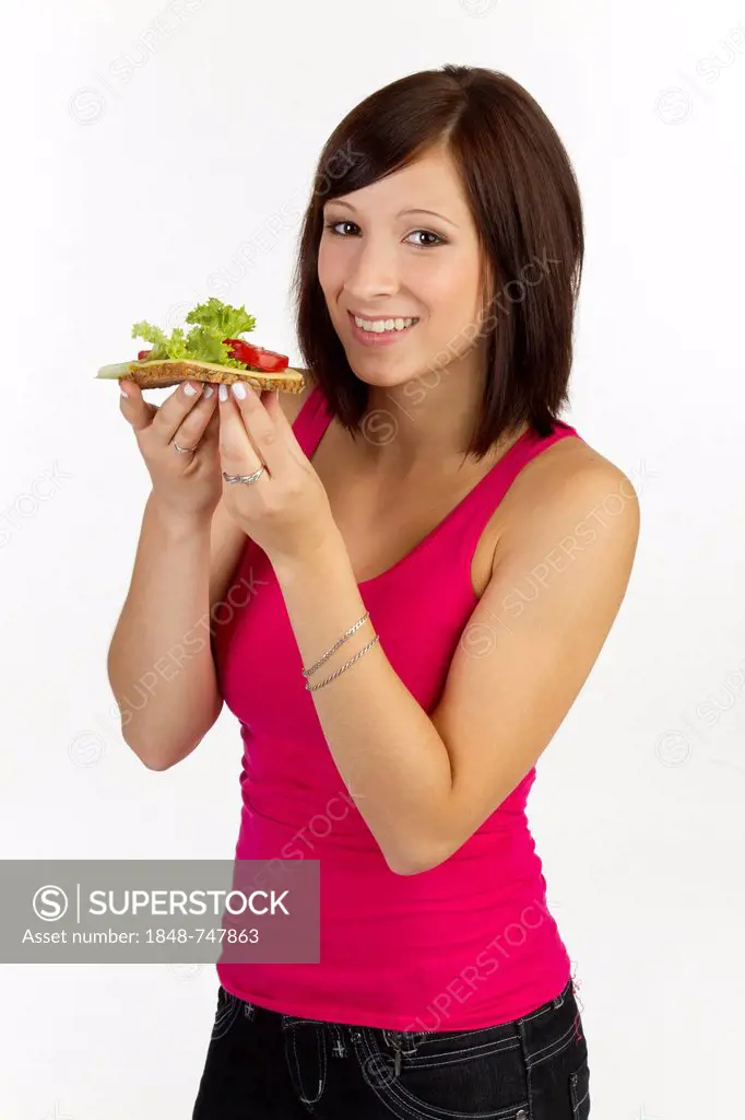 Young woman with grain bread topped with cheese and tomato