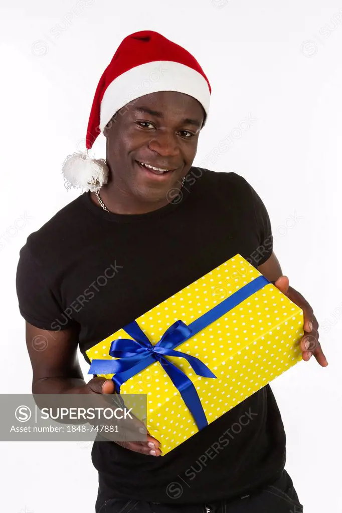 Young black man wearing a Santa hat and holding a present