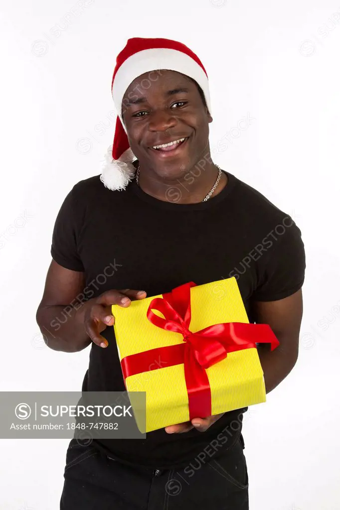 Young black man wearing a Santa hat and holding a present