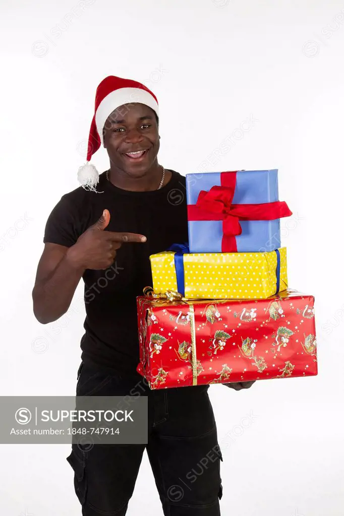 Young black man wearing a Santa hat and holding presents