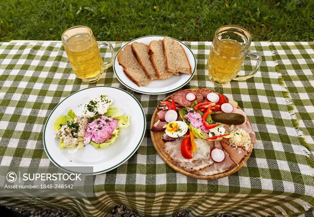 A sausage and cheese platter and some spread on a plate with two glasses of cider, young wine, near Gruenberg, Pyhrn-Eisenwurzen, Traunviertel region,...
