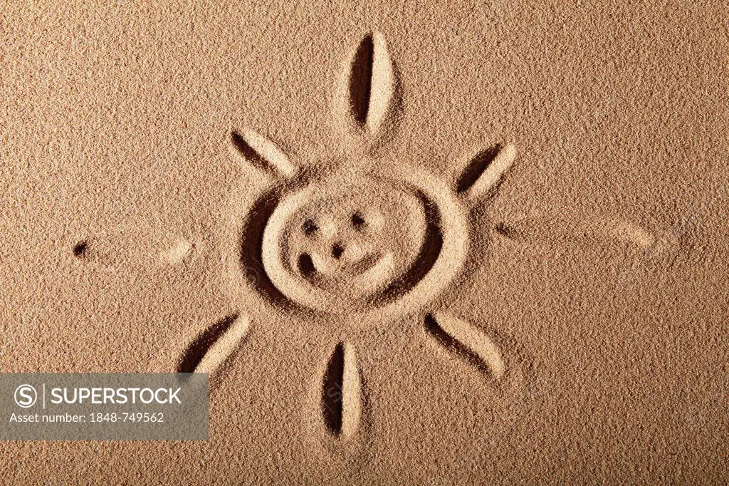 Sun with face painted in the sand