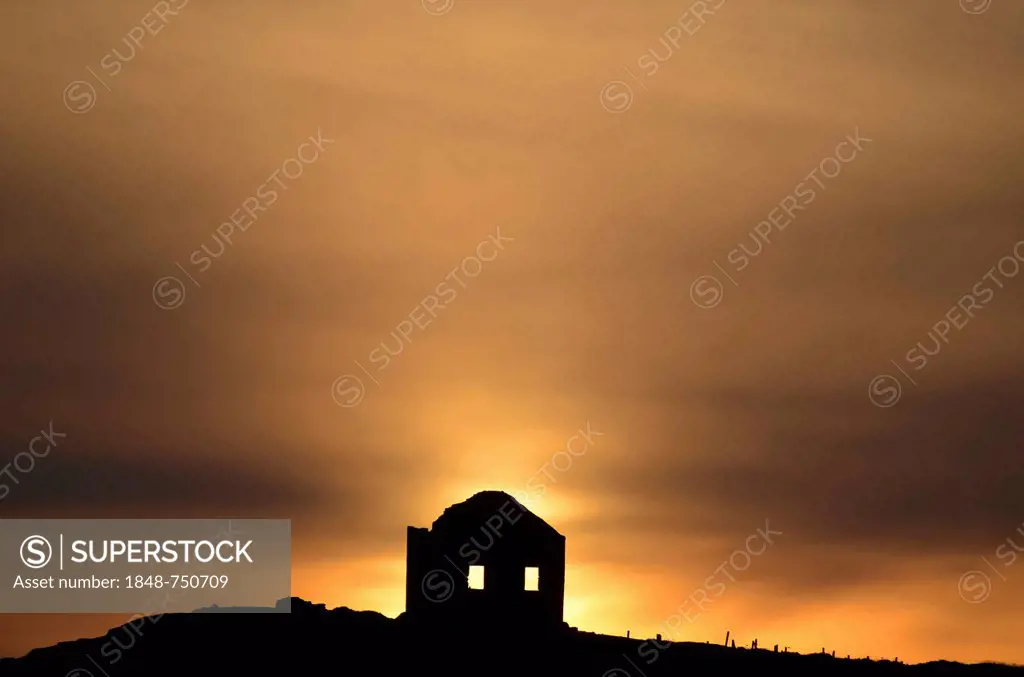 Sunset behind a lone house on a cliff above a beach at the Côte Sauvage on the west side of the Quiberon peninsula, southern Brittany, Bretagne, Franc...