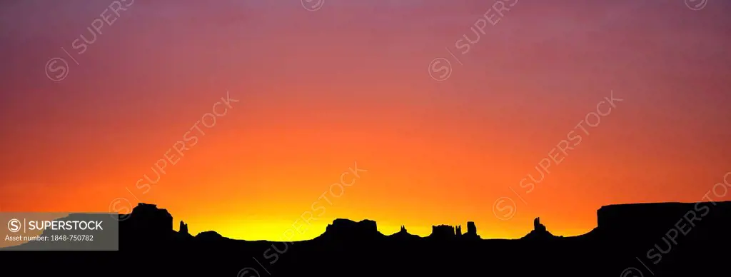 Sunrise at dawn with the mesas of Brigham's Tomb, King on His Throne, Stagecoach, Bear and Rabbit, Castle Butte, Big Indian and Sentinel Mesa, Monumen...