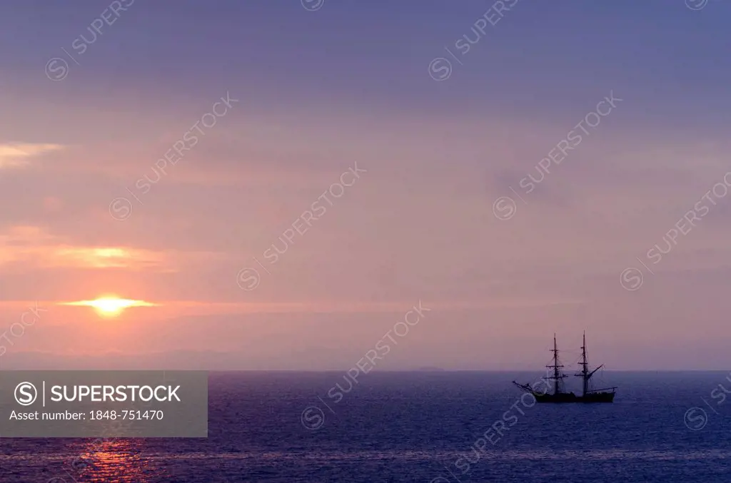 Silhouette of a sailing boat against sunrise, near Port-Haliguen on the east side of the Quiberon peninsula, southern Brittany, Bretagne, France, Euro...