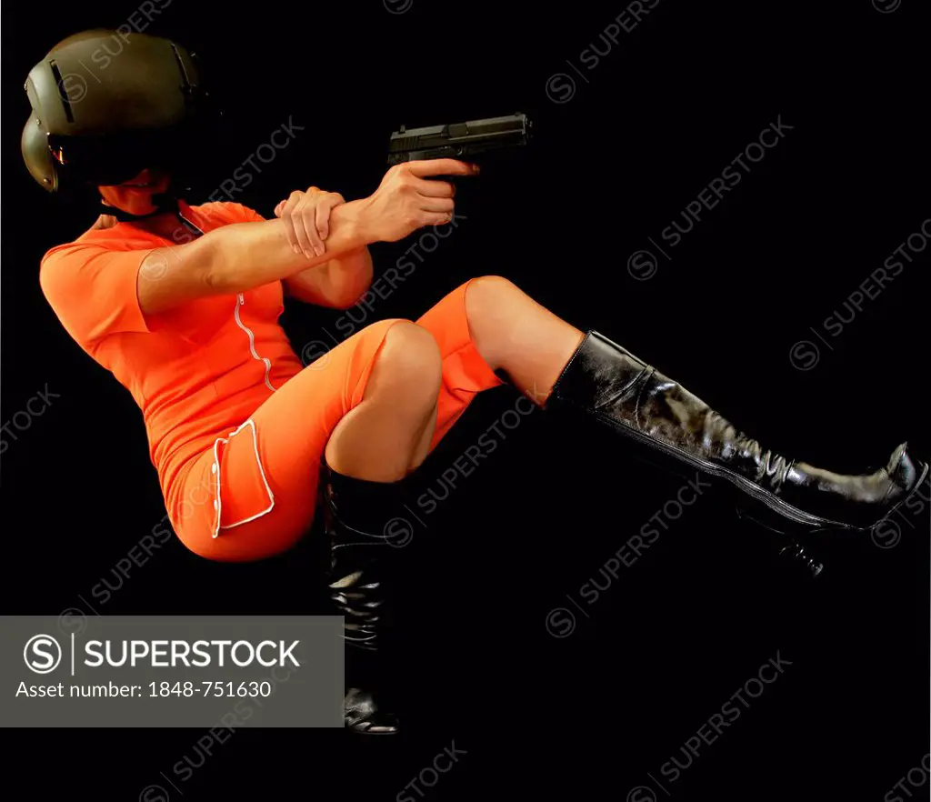 Woman wearing an orange jumpsuit falling backwards firing a gun