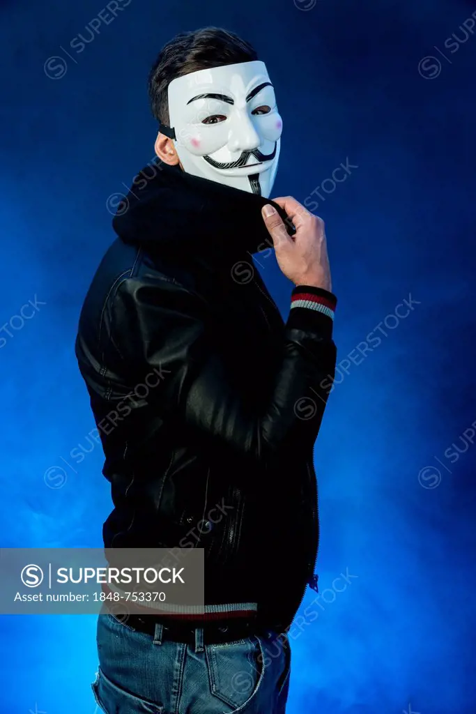 Young man wearing an anonymous mask and a black leather jacket
