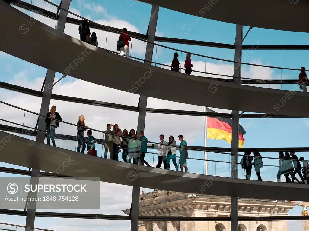 Visitors in the dome of the Reichstag Building and the German national flag, Berlin, Germany, Europe