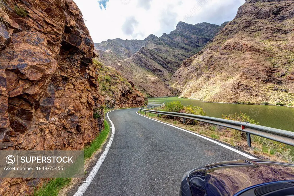 Road at the Embalse Presa del Parralillo reservoir, also called the green lake, in the mountains of Caldera de Tejeda, also called a petrified storm, ...
