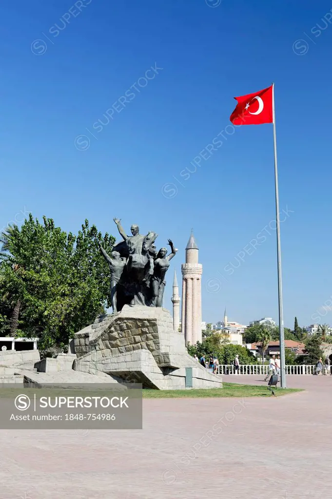 Statue of Mustafa Kemal Ataturk with the Turkish flag in front of the Yivli Minare Mosque in the historic town centre of Antalya, Kaleici, Turkish Riv...