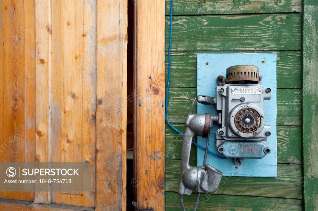 Old phone on the building entrance to the Port Authority in the Russian mining settlement of Barentsburg, Isfjorden, Spitsbergen, Svalbard, Norway, Eu...