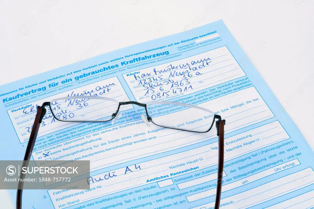 Reading glasses lying on a German purchase agreement