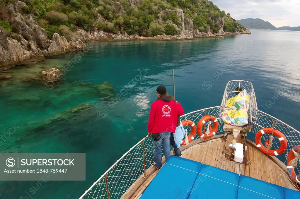 Tourists on yacht looking at the ruins of the sunken city of Kekova, Turkey