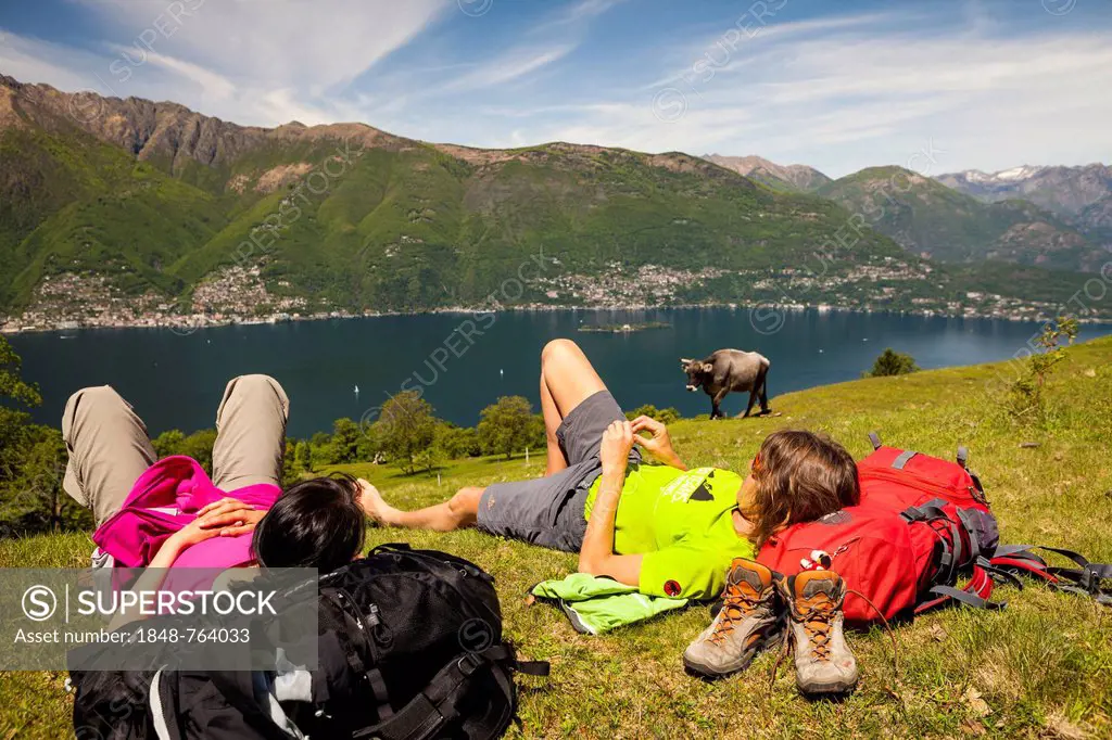 Two women hikers, resting on Monte di Caviano, overlooking lake Lago Maggiore, Ticino, Switzerland, Europe