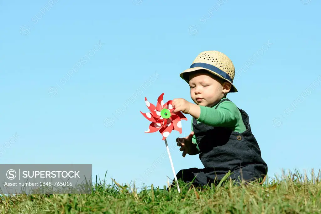 Young boy with a pinwheel, symbolic image for alternative energy and sustainability