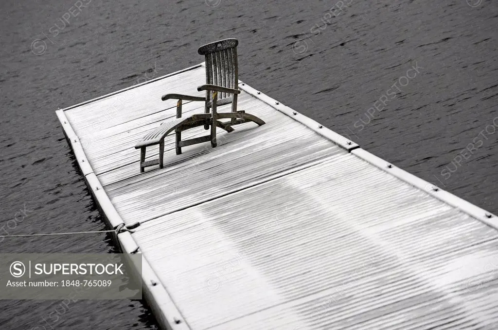 Deck chair on snow-covered jetty at Spitzingsee Lake, Bayrischzell, Bavaria, Germany, Europe