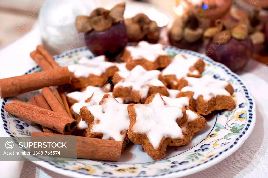 Cinnamon stars, cinnamon sticks and mangosteen fruits on a plate