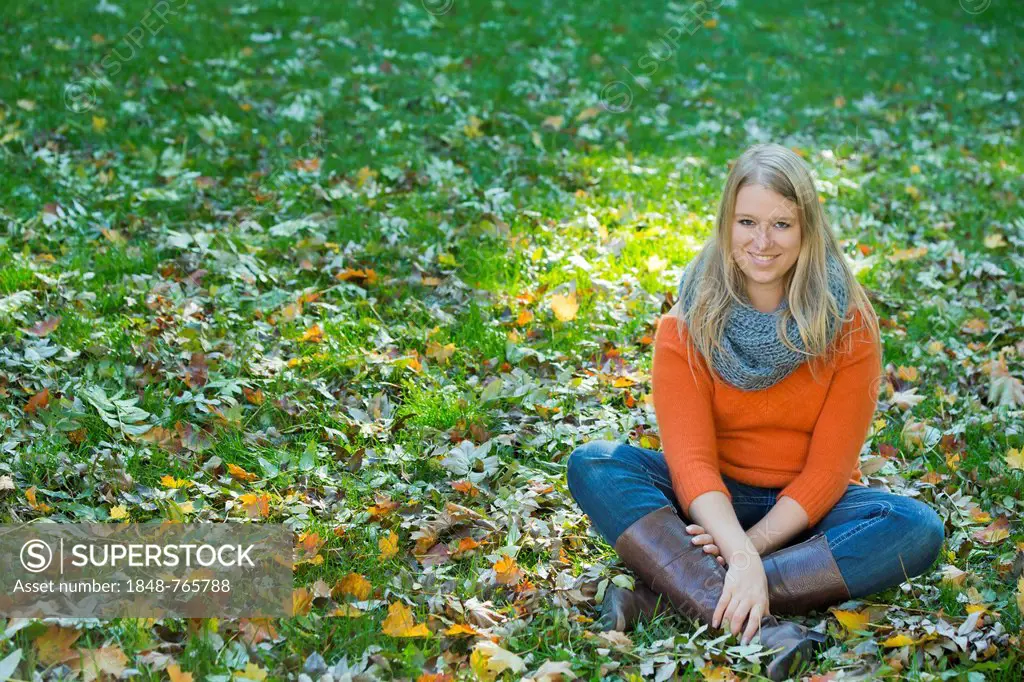 Young woman sitting cross-legged in the grass