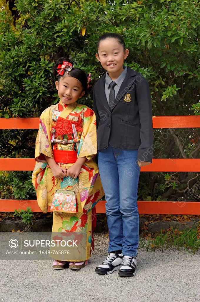 A Japanese girl wearing a kimono and a Japanese girl wearing western clothing, Kyoto, Japan, East Asia, Asia