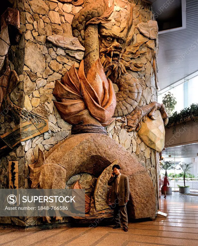 Lobby of the Lippo Centre, artwork made of stone with a man using a mobile phone standing in front, detail, glass facade, Central District, Victoria I...