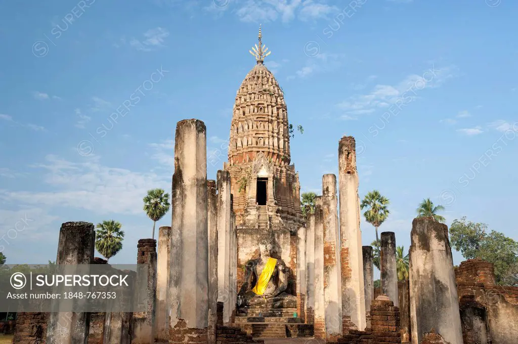 Seated Buddha statue in front of a chedi, temple complex of Wat Phra Si Rattana Mahathat Chaliang, Si Satchanalai Historical Park, UNESCO World Herita...