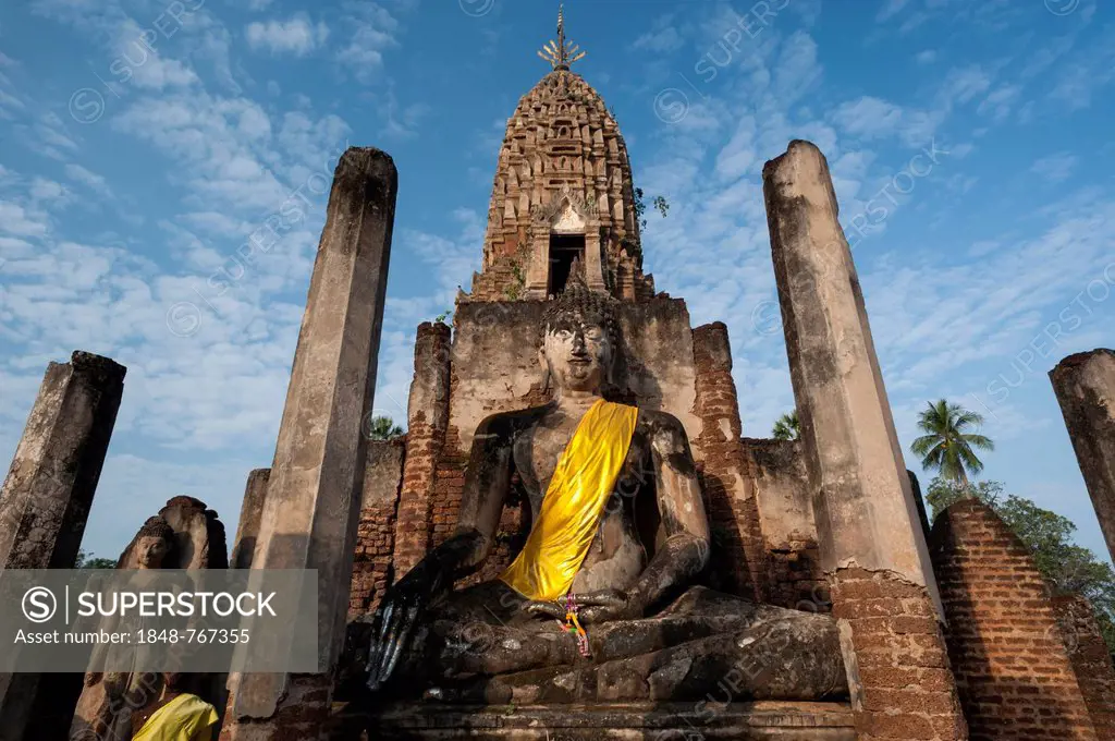 Seated Buddha statue in front of a chedi, temple complex of Wat Phra Si Rattana Mahathat Chaliang, Si Satchanalai Historical Park, UNESCO World Herita...