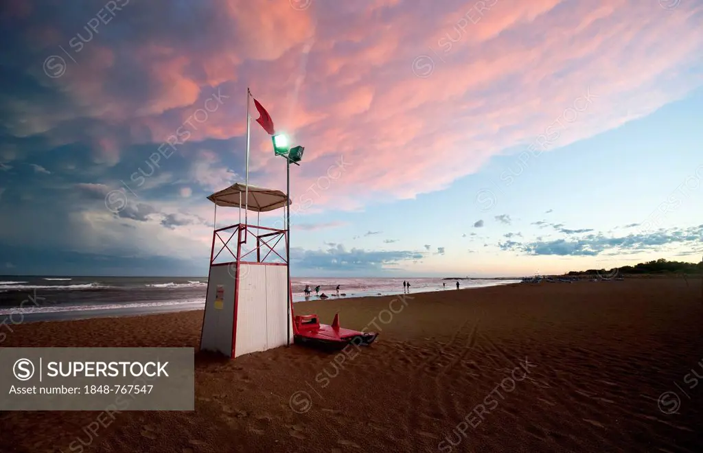 Observation tower on the sea with moody clouds and the afterglow of sunset
