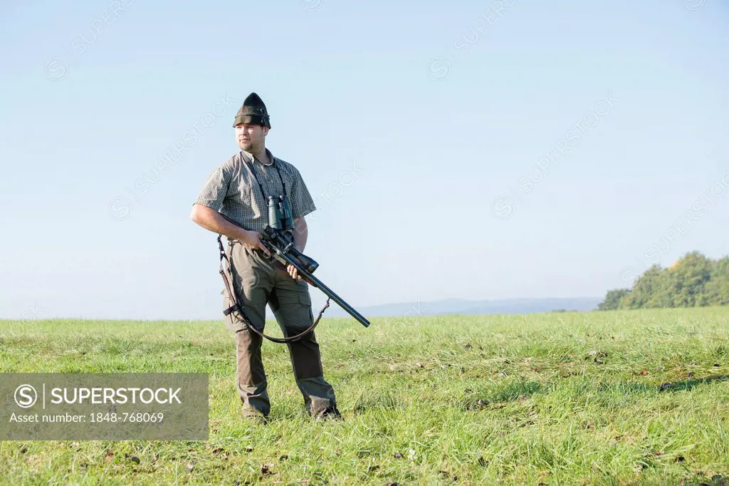 Hunter standing on a meadow, waiting for game